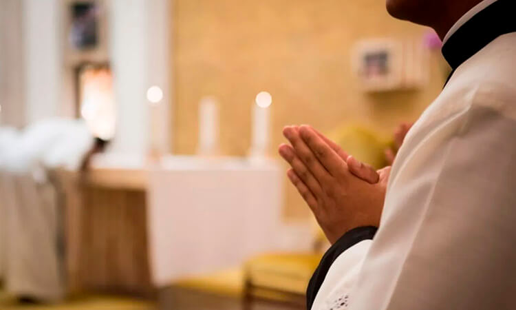 Persona rezando en una iglesia/Sacerdotes